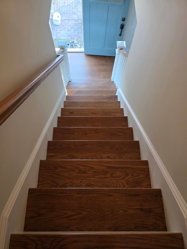 Wood staircase with brown stain and finished treads — I&P Flooring project