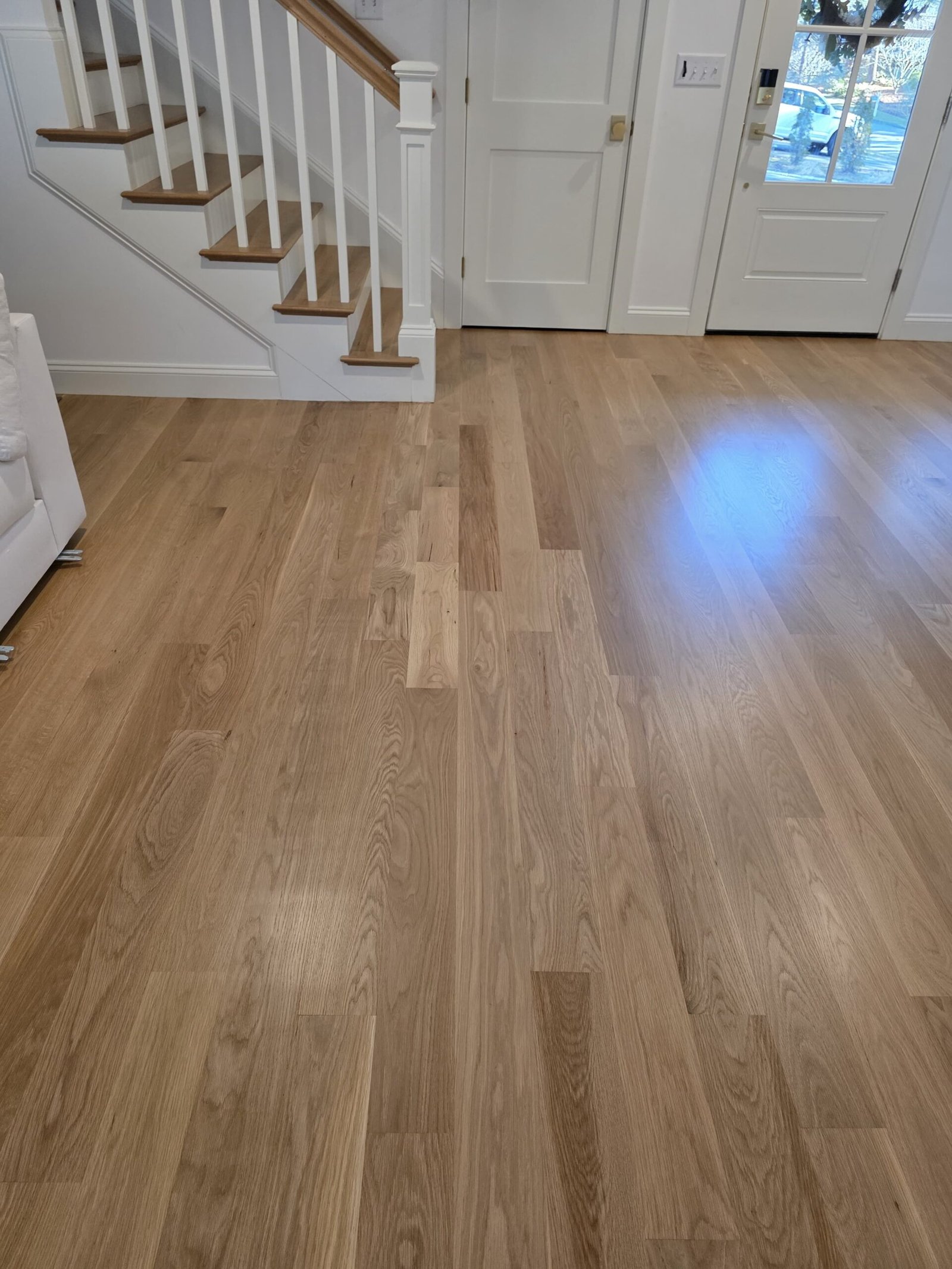Finished hardwood floor beside a white staircase — I&P Flooring project