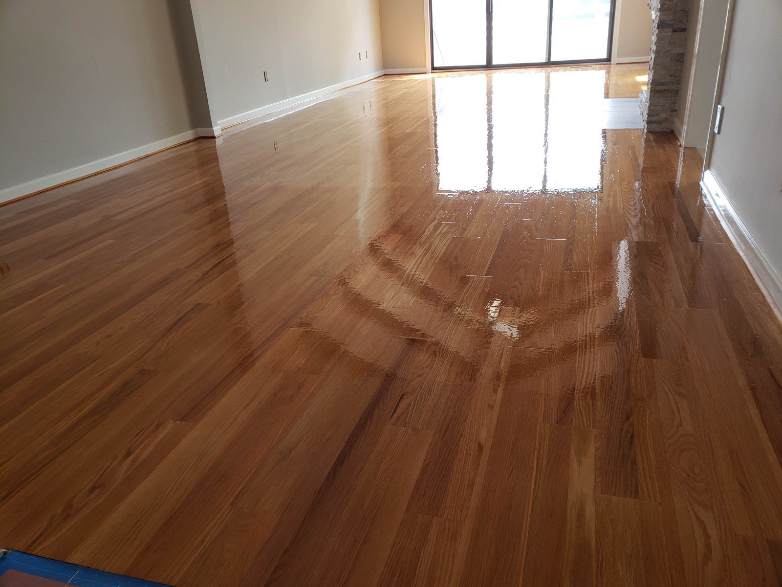 Refinished hardwood floor with a glossy finish — I&P Flooring project